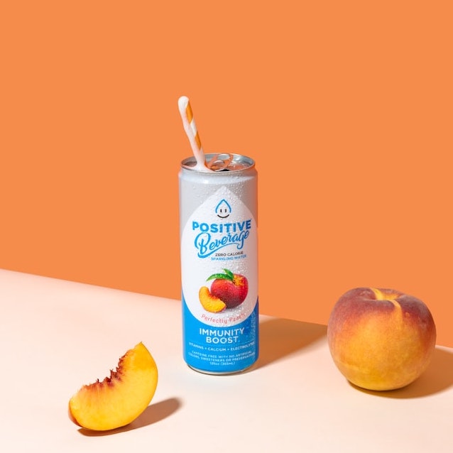 A can drink in front of an orange backdrop