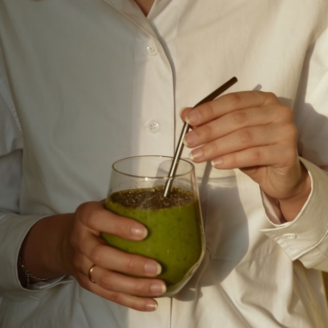 A model holding a cup of green tea smoothie